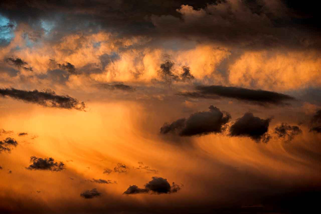 wolken in fließendem abendlicht, zwischen dunkel und gold